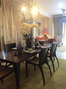 a dining room table with chairs and a chandelier at Amisha Home Design & Comfortable 2 Bedrooms Apartment in Petaling Jaya