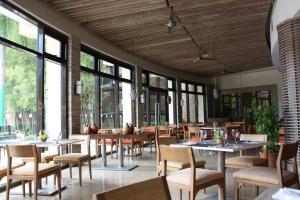 a dining room with tables and chairs and windows at Unit 507 Pico De Loro in Nasugbu