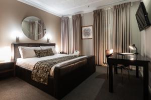 a bedroom with a bed and a desk and a mirror at Clarendon Hotel in Newcastle