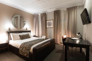 纽卡斯尔Clarendon Hotel的卧室里有一张床、一张书桌和一面镜子