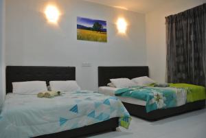 a bedroom with two beds with stuffed animals on them at Wave Langkawi Inn in Pantai Cenang