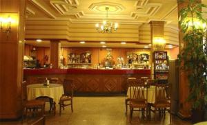 a restaurant with a bar and tables and chairs at Hotel Santa Teresa in Avila