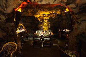 a restaurant with tables and chairs in a cave at The President Hotel in Bangalore