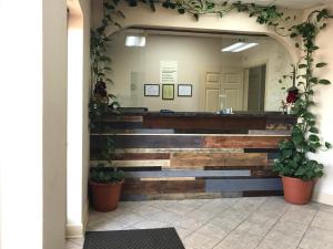 een wachtkamer met een spiegel en potplanten bij Legacy Inn - Gallatin in Gallatin