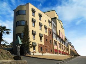 a yellow building with a tower next to a street at Hotel.COM (Adult Only) in Nagoya