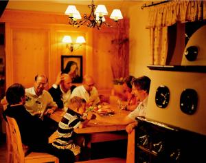 um grupo de pessoas sentadas à volta de uma mesa a comer em Schreiners Berghof em Hartberg