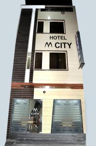a building with two garage doors and a hotel city at Hotel M City in Amritsar