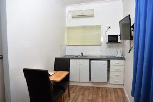 a small kitchen with a table and a sink at Chinchilla Motel in Chinchilla