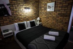 
a bedroom with a bed and a wall mounted wall mounted wall mounted wall mounted at Park House Motor Inn in Oakey
