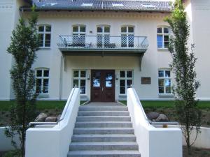 ein Haus mit einer Treppe, die zur Eingangstür führt in der Unterkunft Jagdschloss zu Hohen Niendorf in Kühlungsborn