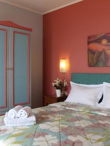 a bedroom with a large bed with towels on it at Amaryllis Hotel Apartments in Tolo