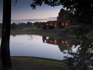 a house sitting next to a body of water at Whispering Waters in Fort Nottingham