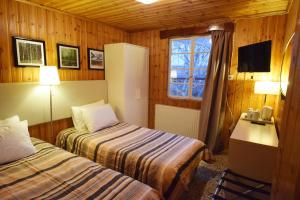 a hotel room with two beds and a window at Christys Palace Hotel in Pedoulas