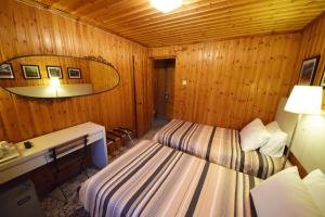a room with two beds in a wooden room at Christys Palace Hotel in Pedoulas