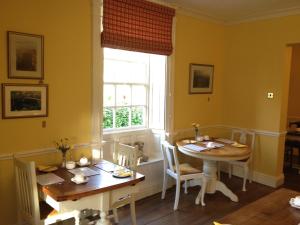 a dining room with two tables and a window at Calcutts House in Ironbridge