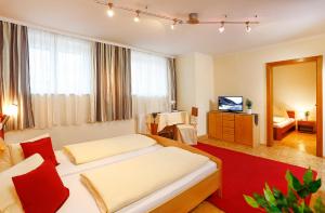 a hotel room with two beds and a television at Pension Sendlhofer in Radstadt