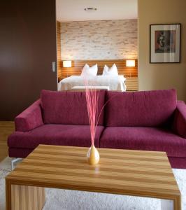 sala de estar con sofá púrpura y cama en Schreiners Berghof, en Hartberg