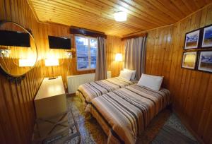 a bedroom with two beds in a wooden room at Christys Palace Hotel in Pedoulas