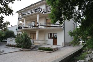 a white house with a porch and a balcony at Apartment Ivana in Novi Vinodolski