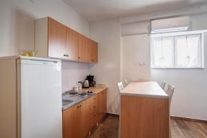 cocina con armarios de madera y nevera blanca en Apartment Noa, en Šibenik
