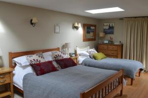 a bedroom with two beds and a dresser at Motts Bed & Breakfast in Great Dunmow