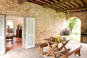 Bucine的住宿－Fattoria Casabianca，一间设有桌子和石墙的用餐室