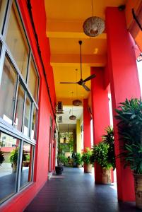 einen leeren Flur eines Gebäudes mit roten und gelben Wänden in der Unterkunft Wau Hotel & Cafe in Jerantut