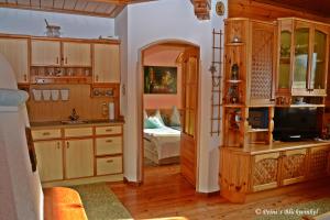 a kitchen with wooden cabinets and a bedroom with a bed at Haus Obermoser in Dellach im Drautal