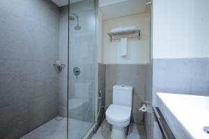a bathroom with a shower and a toilet and a sink at J Hotel Kuta in Kuta +20 photos