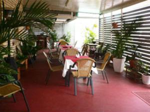 a restaurant with tables and chairs and potted plants at Chinchilla Motel in Chinchilla