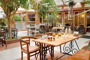 a restaurant with wooden tables and chairs and trees at Hotel Niky in Sofia