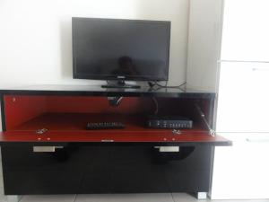 TV en la parte superior de un centro de entretenimiento de madera en Appartement Fodéré 2, en Niza