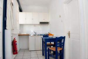 una pequeña cocina con mesa azul y sillas en Karfas Bay View, en Karfas
