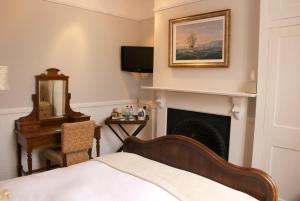 ein Schlafzimmer mit einem Bett und einem Kamin in der Unterkunft Chantry Hotel in Bury Saint Edmunds