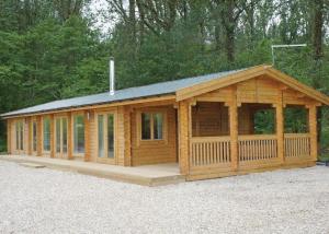 a large wooden cabin with a gambrel roof at Peckmoor Farm Lodges in Misterton