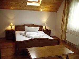 a bedroom with a bed with white sheets and a table at Vila Alisa in Bran +68 photos