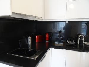 a kitchen with white cabinets and a black counter top at Alojamentos Casa Facha Menta in Portalegre