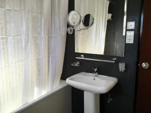 a bathroom with a white sink and a mirror at Dorchester in Nuwara Eliya