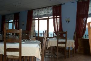 ein Esszimmer mit Tischen und Stühlen und einem Fenster in der Unterkunft Hotel Palazio in Nerín