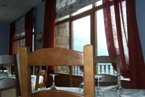 ein Tisch mit zwei Stühlen an einem Tisch mit Fenster in der Unterkunft Hotel Palazio in Nerín