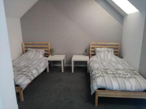 - 2 lits dans une chambre avec 2 tables dans l'établissement Kniepwiekerhof, à Neukamperfehn