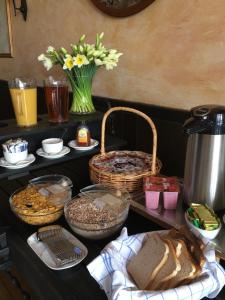 a table with bread and baskets and a vase with flowers at The Penta in Douglas