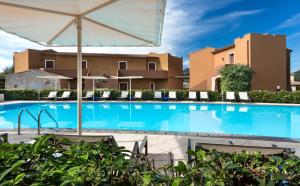 a large swimming pool with chairs and an umbrella at Terradimare Resort&Spa in San Teodoro