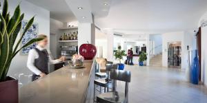 a man standing at a bar in a restaurant at Terradimare Resort&Spa in San Teodoro +74 photos
