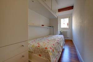 a small bedroom with a bed with a flowered blanket at La Casetta in Venice
