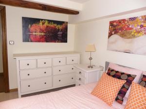 ein Schlafzimmer mit einer weißen Kommode und einem Bett in der Unterkunft Urrondo in Lekeitio