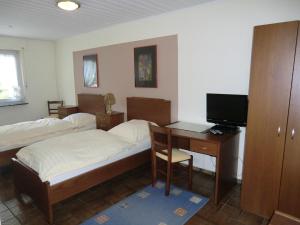 1 Schlafzimmer mit 2 Betten und einem Schreibtisch mit einem Computer in der Unterkunft Hotel-Restaurant Artemis in Willich