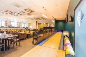 uma pista de bowling com alfinetes num restaurante em Hotel Gatsby by HappyCulture em Chassieu