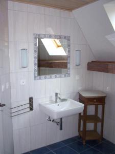 een badkamer met een wastafel en een spiegel bij GÎte rue de l'Ange in Hunspach