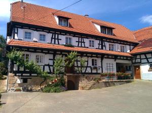 een zwart-wit gebouw met een oranje dak bij GÎte rue de l'Ange in Hunspach